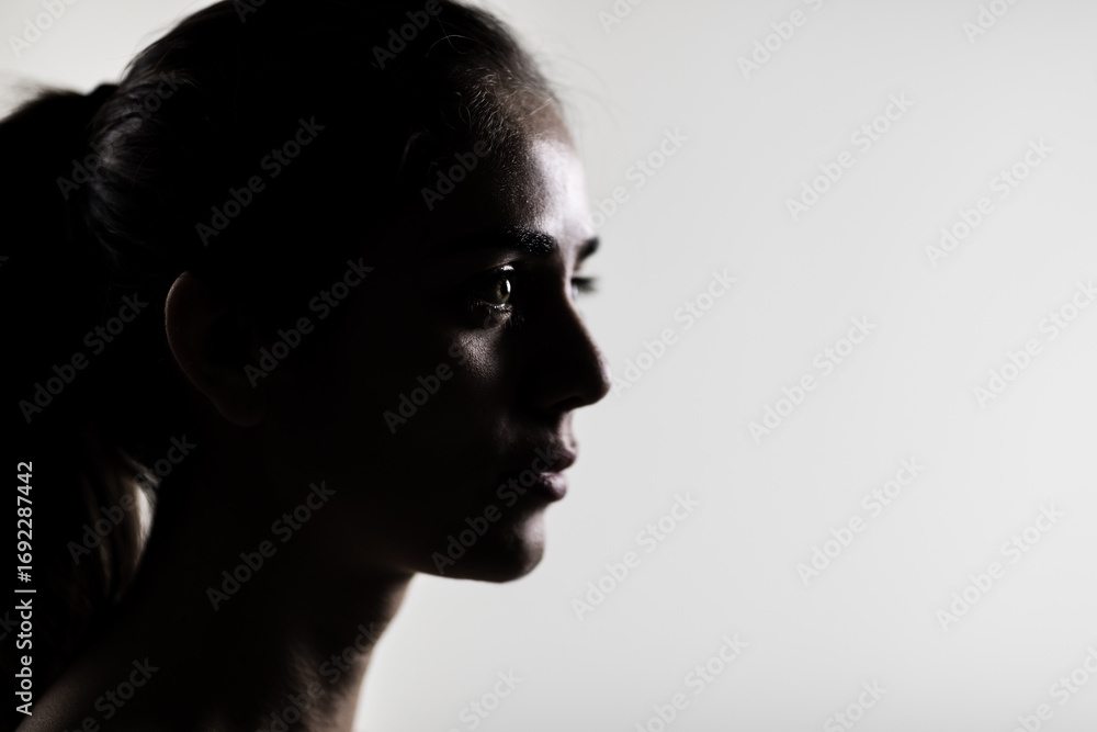 Fototapeta premium Elegant young woman in silhouette, side profile in studio setting