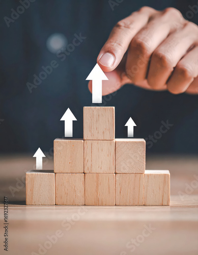 Close up hand and stack of wood block cube on the table.