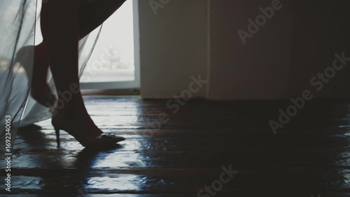 black silhouette close-up feet body part woman sexy fashion model walking dressed in classic high heel shoes long legs white silk dress. Girl go foot step old wooden floor. dark room window light 4k