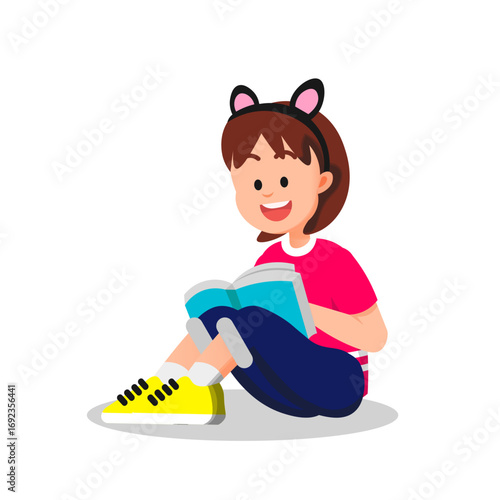 A little girl reads a book while wearing cat ear accessories