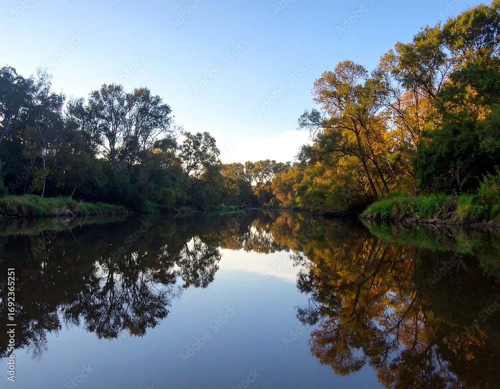 Fototapeta premium Calm river reflecting autumn trees
