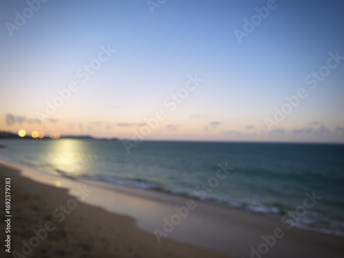 Wallpaper Mural Blurred beach scene with ocean waves sand and distant lights under a twilight sky view Torontodigital.ca
