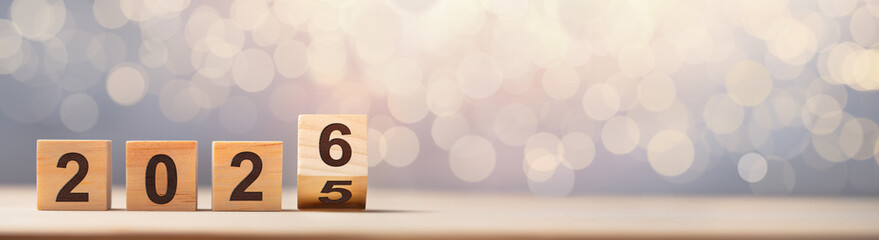 Flipping of 2025 to 2026 on wooden block cube for preparation new year change.New Year concept.