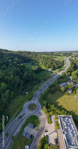 Sougne-Remouchamps, Aywaille, Liege, Wallonie, Belgium, August 10, 2025, Aerial photograph shows a roundabout on a highway amidst vibrant green landscapes stretching far and wide