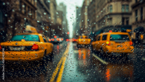 Yellow new york city taxis driving down a wet street during a rainy day with reflections