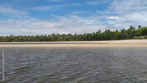 Waves of pure blue kiss the golden sands of Castelhanos Beach on Boipeba Island, Brazil.