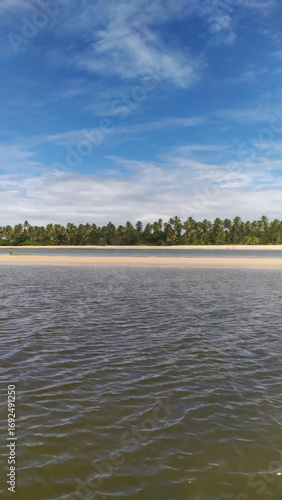Waves of pure blue kiss the golden sands of Castelhanos Beach on Boipeba Island, Brazil.