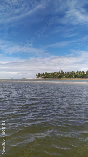 The crystal blue waters of Castelhanos Beach sparkle under the tropical sun on Boipeba Island, Bahia, Brazil.