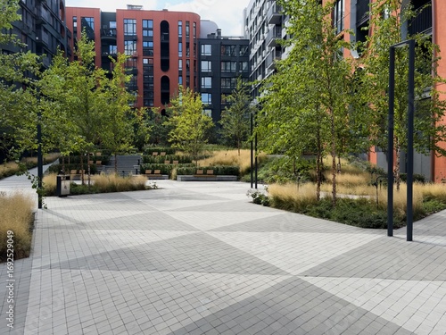  Background of Modern Urban Courtyard with Abstract Sculpture Surrounded by Lush Greenery and Contemporary Architecture. Blurry Background For Design Projects.