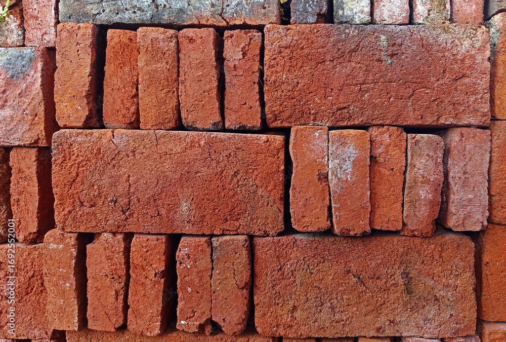 A stack of rough red bricks with a porous texture and varying colors. Suitable for backgrounds or textures A stack of rough red bricks with a porous texture and varying colors. Suitable for backgrounds or textures