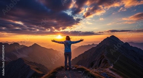 Woman with outstretched arms on mountain peak at sunset, celebrating freedom and success.