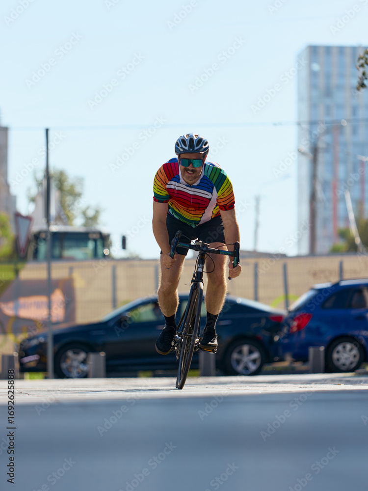 Obraz premium Cyclist racing forward on city road with strong focus. Concept of urban fitness, sports endurance, personal determination, motivation, and emotional strength.