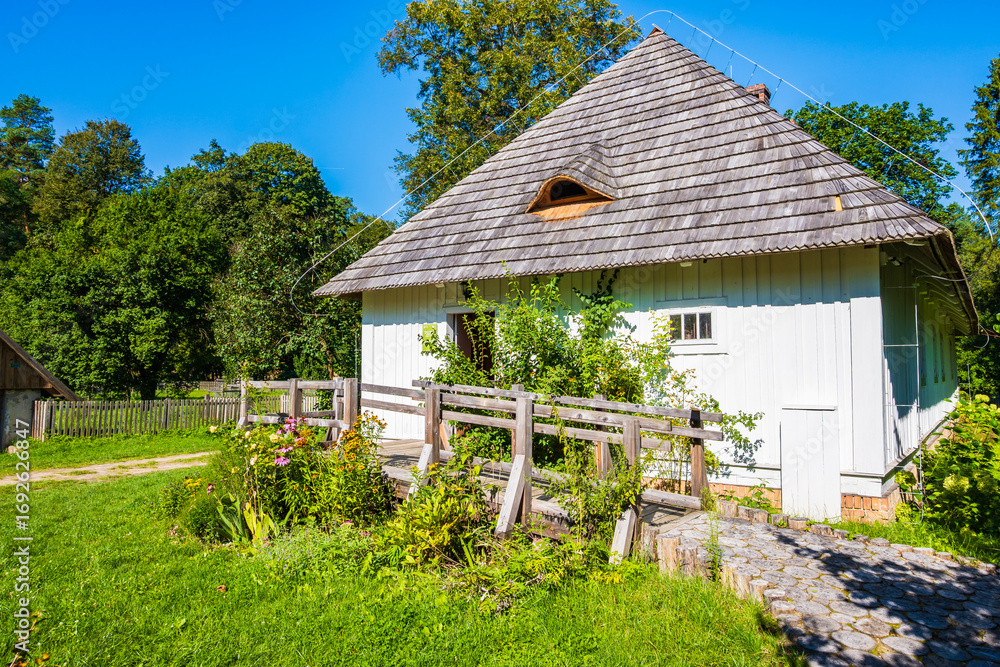 Obraz premium Rustic old wooden house on green meadow, Roztocze National Park, Poland