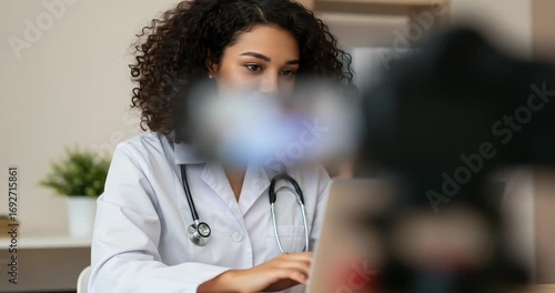 Female doctor working on laptop in modern office