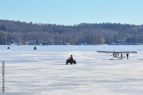 ATV and airplane over frozen lake in winter