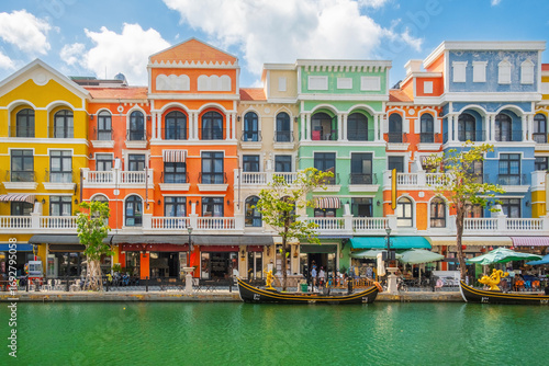 Colorful European style buildings and gondolas along peaceful canal on Phu Quoc island, Vietnam, with cafes, shops and tourists enjoying the vibrant waterfront. Grand world city. Italian architecture