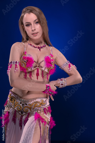 Dancer with long hair in bright oriental costume dancing belly dance 