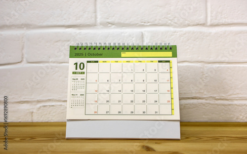 The desktop calendar for October 2025 is on the desk, where there is a place to copy.