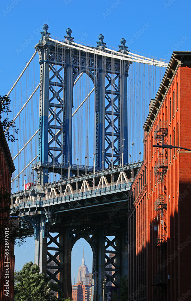 Fototapeta premium view of the Manhattan Bridge from DUMBO with the Empire State Building framed by red brick buildings
