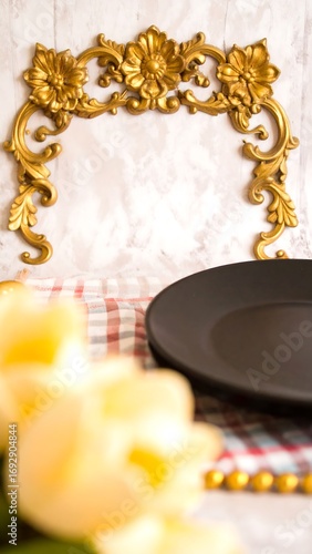 Ornate gold frame with a black plate and flowers