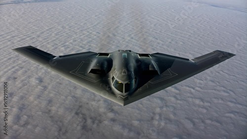 A b2 spirit stealth bomber glides through the air above a sea of clouds, displaying its distinctive shape