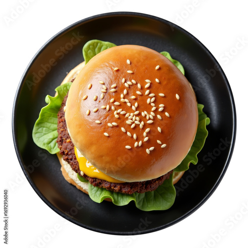 Delicious gourmet burger with sesame seed bun served on a black plate isolated view