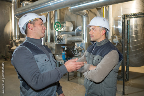 Fototapeta factory workers conversing in the pipe area