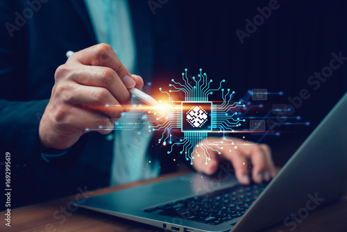 Businessman using digital pen with holographic microchip and circuit board above laptop. Concept of artificial intelligence, computing, processor technology, digital innovation, and future business.