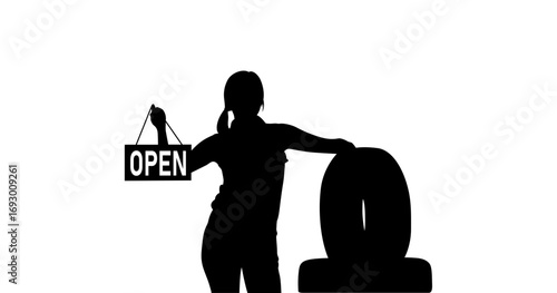 A strong, confident female silhouette stands in front of a large tire, holding an "OPEN" sign.