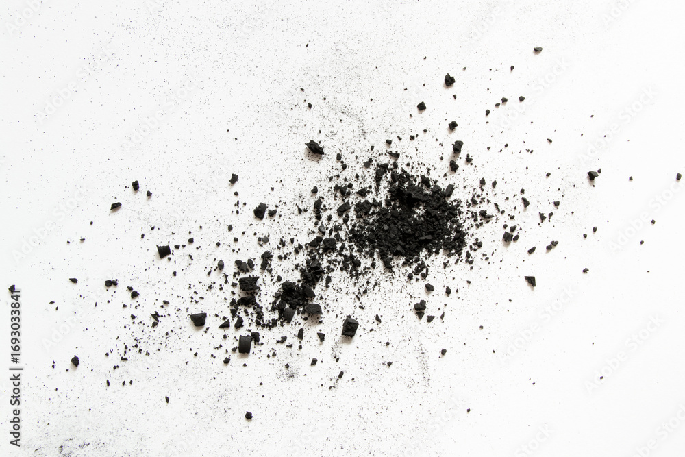 Fototapeta premium Scattered coal crumbs and dust on white background as texture