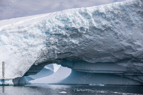 Fotografía large iceberg with arch opening near Yalour Islands Antarctica