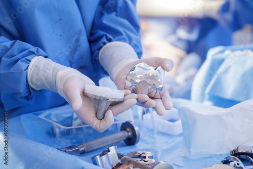Surgeon holding knee replacement prosthesis components in a sterile orthopedic setting