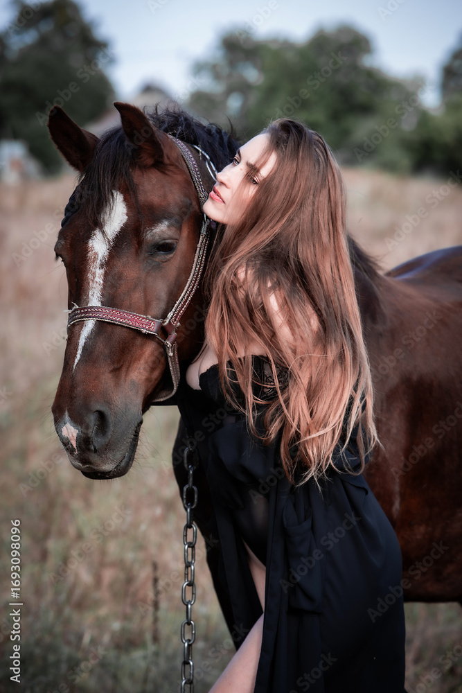 Obraz premium Young beautiful sexy woman in a cloak and lace lingerie corset is walking with a horse in nature. Freedom. Friendship and loyalty. Peace of mind. Portrait. 