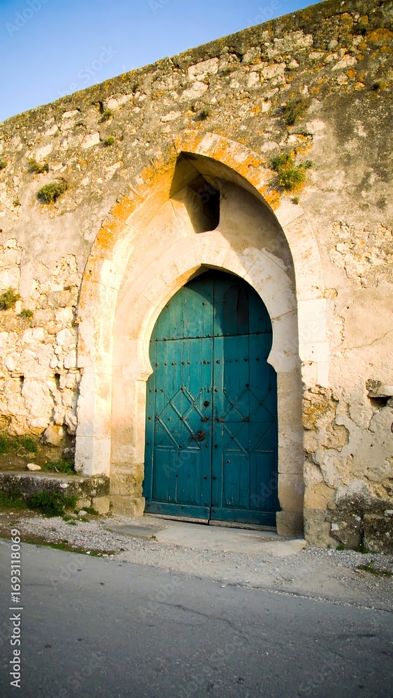Fototapeta premium Aged stone archway with teal door