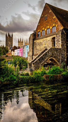 Old house ont the river with a cathedral in the distance