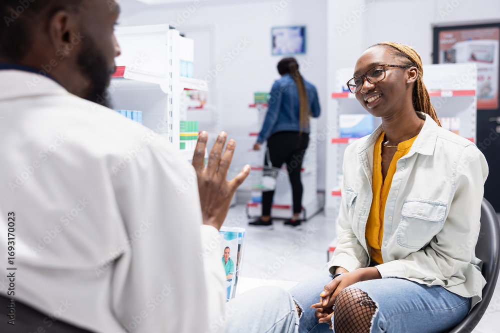Obraz premium Pharmacy worker assisting a customer with detailed pharmacist advice, explaining medicine and health products in a busy retail drugstore. Pharmaceutical care and patient wellbeing.