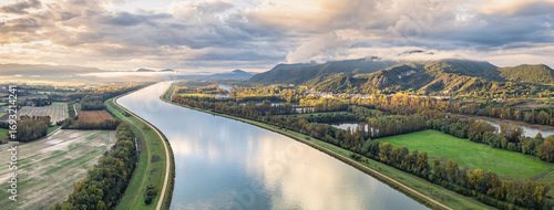 Vászonkép Sunrise Landscape over Rhone River in France with Mountains, Fields and Scenic N