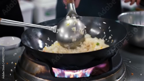 Chef cooking fried rice with wok flame.