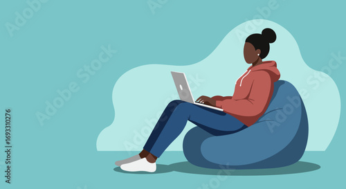 Relaxed young woman working or studying on a laptop from the comfort of her home, sitting on a bean bag. Modern lifestyle and remote work.