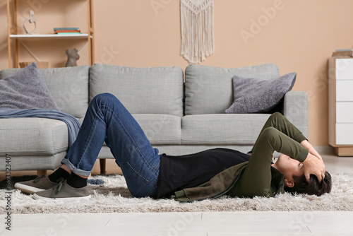 Depressed young man lying o...