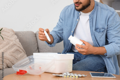 Young man taking pills and ...