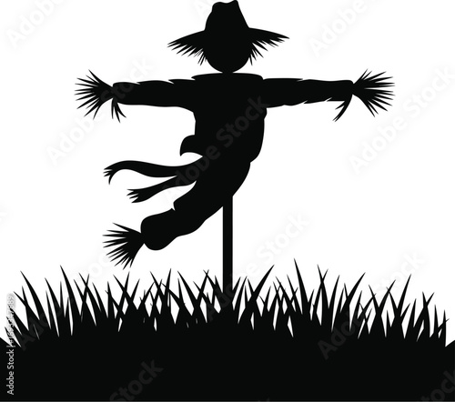 Black scarecrow with outstretched arms in grass silhouette