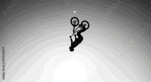 Silhouette of a cyclist performing a stunt against a grayscale gradient background evoking action