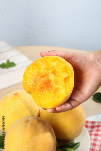 Fresh Yellow Peach Half in Hand - Ripe Juicy Fruit from Shanghai China