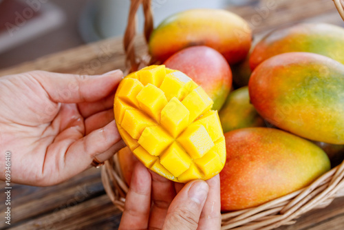 Fresh Mango Diced in Hands with Colorful Tropical Fruits in Wicker Basket
