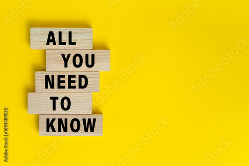 all you need to know words text symbol on wooden blocks isolated on yellow background