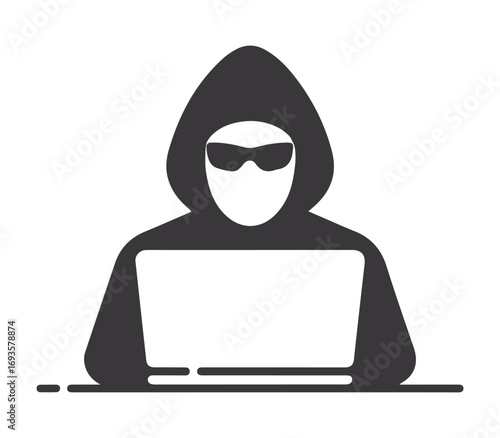 Anonymous hacker wearing sunglasses and a hoodie works on a laptop computer in silhouette