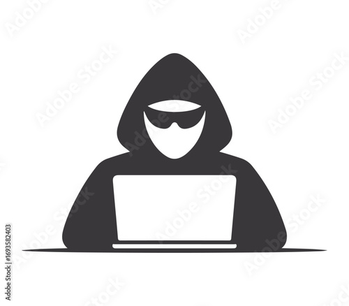 Anonymous hooded figure wearing sunglasses working on a laptop computer representing cybercrime
