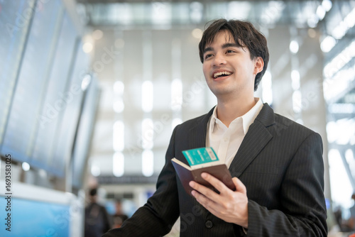Asian businessman passenger checking departure boarding pass in airport. 