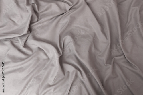 Texture of gray bed sheet, wavy fabric background